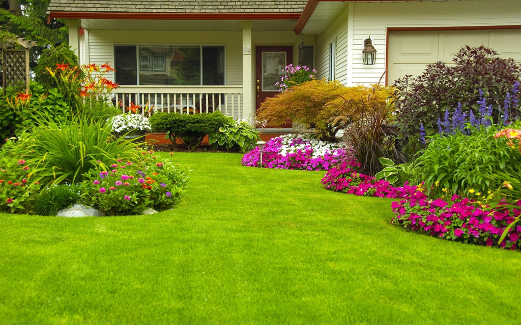 lush green front yard lawn with colorful flower beds and professional landscaping