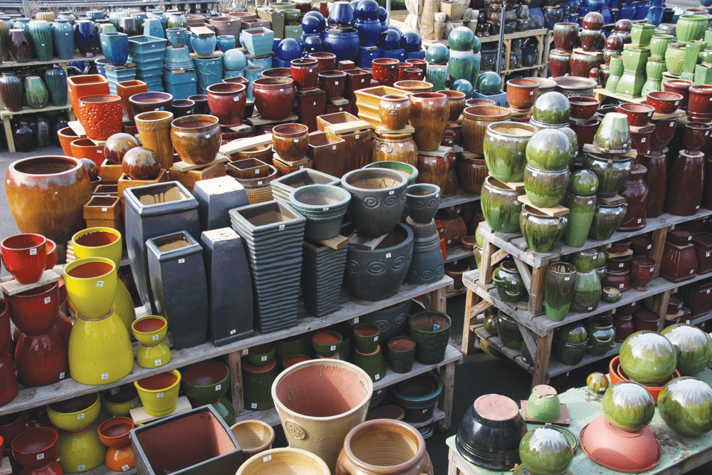 Pots piled high on racks in a gardening store's warehouse.