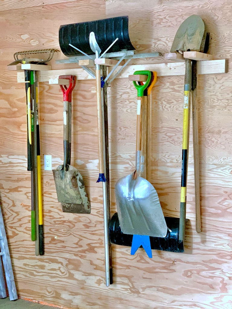 Gardening tools hanging on DIY homemade racks.