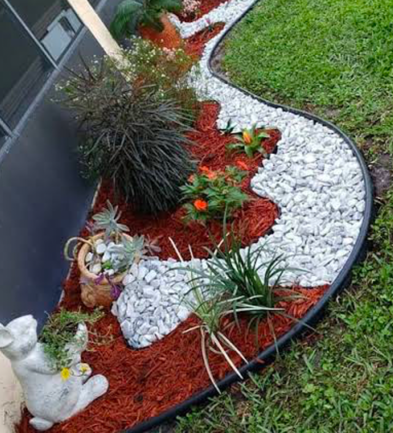 Curved garden edging using white rocks and red mulch for a low-maintenance border