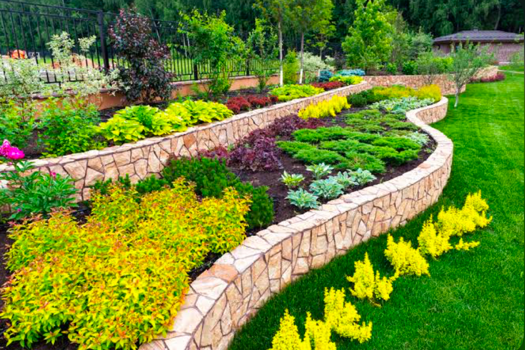 A tiered back yard landscaped with colorful plants.