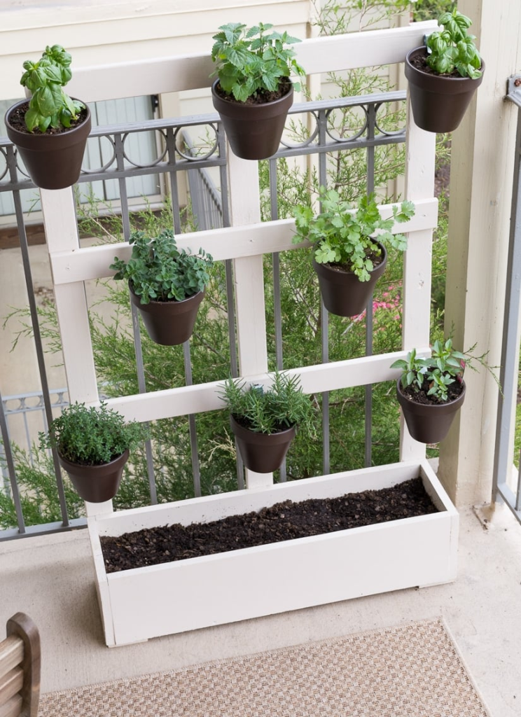 repurposed pellet being used as a planter holder on a balcony.