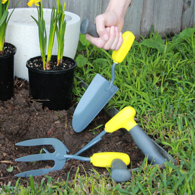 Ergonomic handled Gardening tools being used to transplant plants from containers to the soil.
