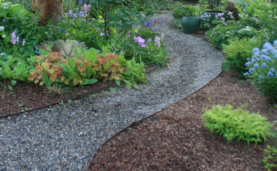 Curved gravel path lined with lush flowering plants