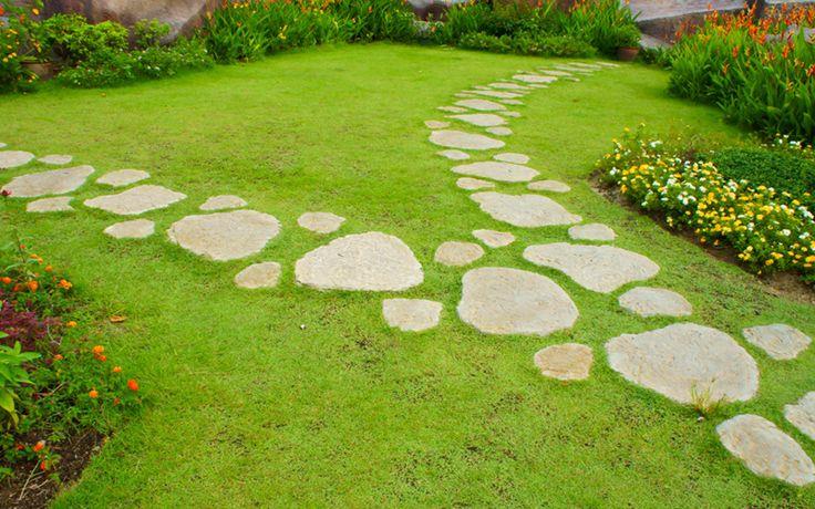 Irregular stone path crossing a green lawn.