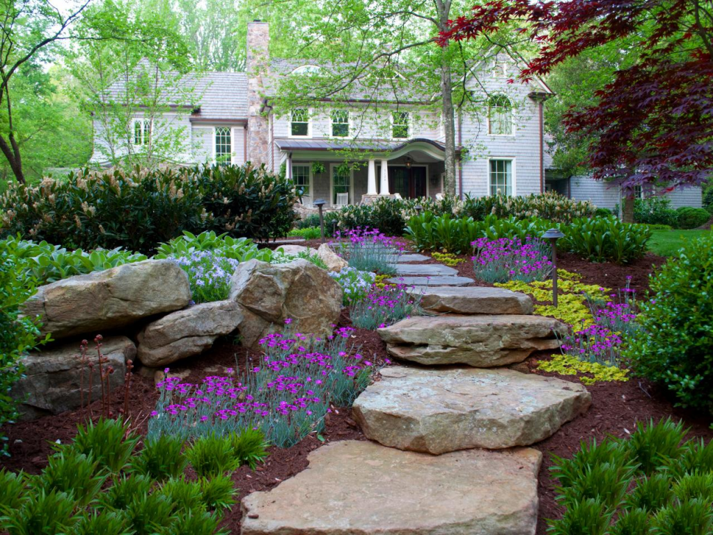 Stones pathway passing through the home's front yard garden leading to its entryway.