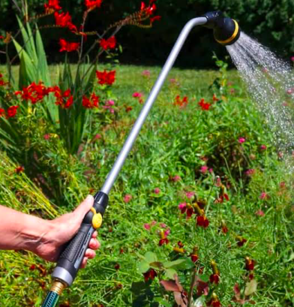 A water wand being used to water a garden.