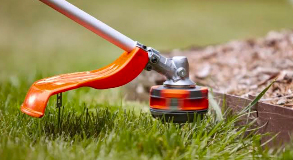 A String Trimmer working hard along the edge of a lawn.
