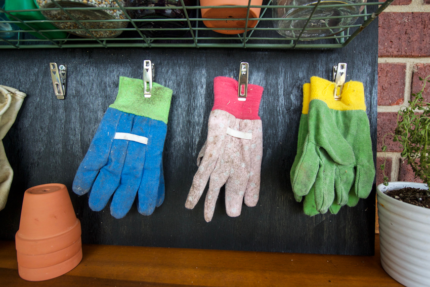 Gardening gloves on a DIY clipboard storage rack.