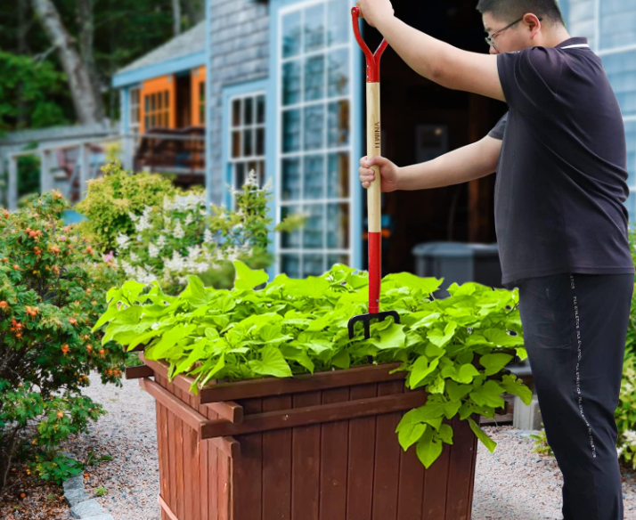 A gardener using a Garden Fork on a large container plot.