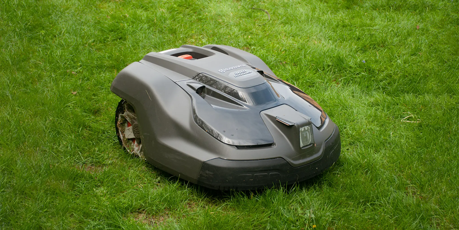 Husqvarna Automower robotic lawn mower cutting backyard grass.