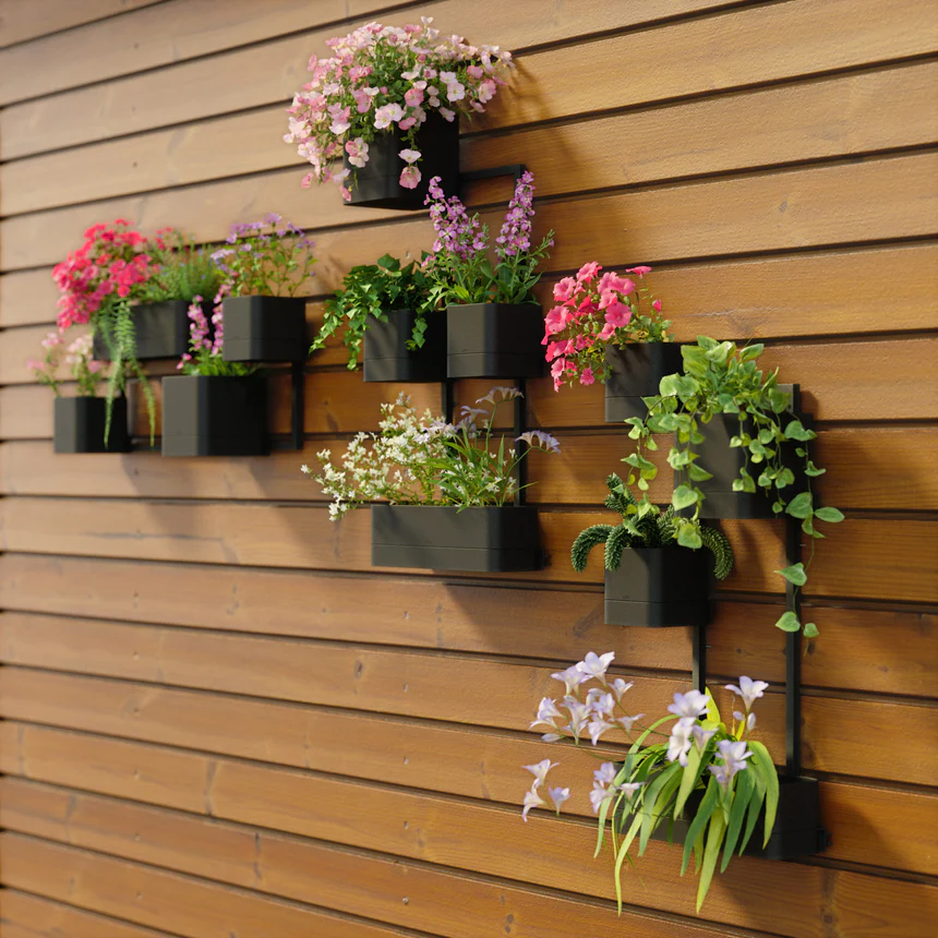 Wall-mounted planter boxes displaying colorful flowers on a modern wooden fence